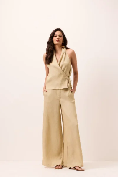 Calça pantalona areia em tecido canelado leve, cintura média/alta, cós com zíper e gancho, bolsos laterais e perna ampla longa