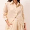 Camisa feminina de rami amarelo manteiga, modelagem solta, manga longa e botões de madrepérola