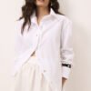 Camisa branca feminina oversized em tricoline de algodão com botões de madrepérola e vista curvada