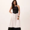 Vestido midi preto e branco sem mangas com busto em lastex, cintura em bico e saia rodada com faixa preta na barra